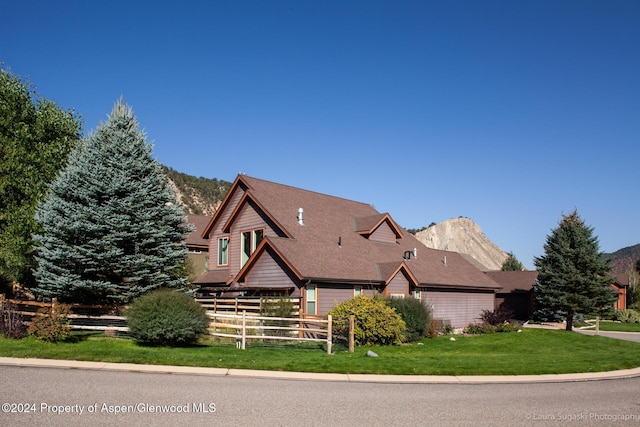 view of front of home with a mountain view and a front yard