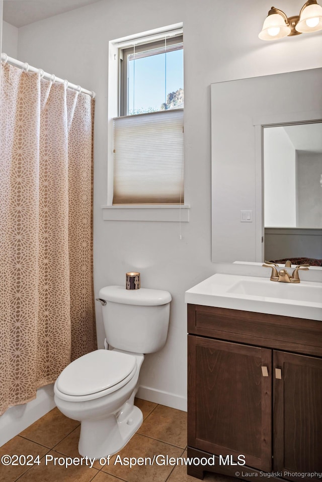 bathroom with toilet, vanity, and tile patterned floors