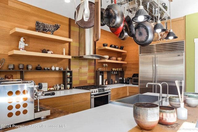 kitchen with wall chimney exhaust hood, backsplash, and appliances with stainless steel finishes