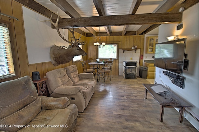 living room featuring beamed ceiling, wood walls, hardwood / wood-style floors, and a chandelier