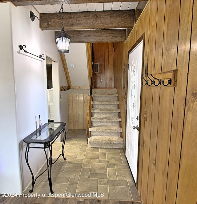 foyer entrance with beam ceiling, wooden ceiling, and wood walls