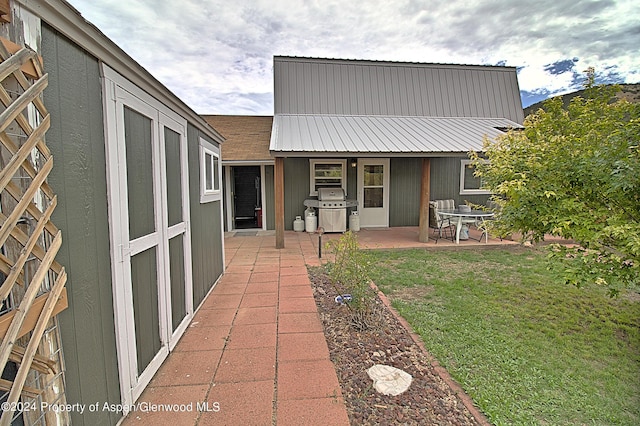 rear view of property with a yard and a patio area