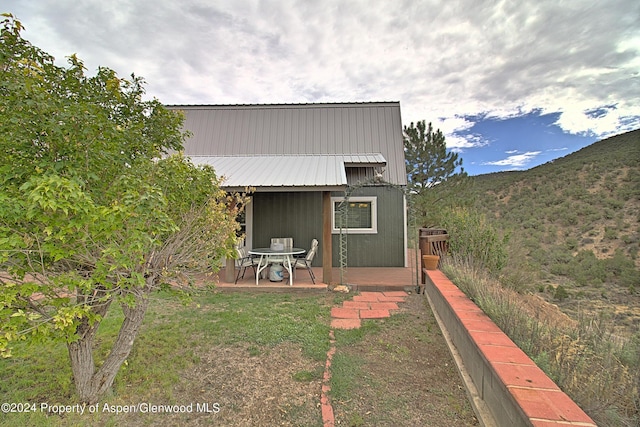 rear view of property featuring a mountain view and a patio area