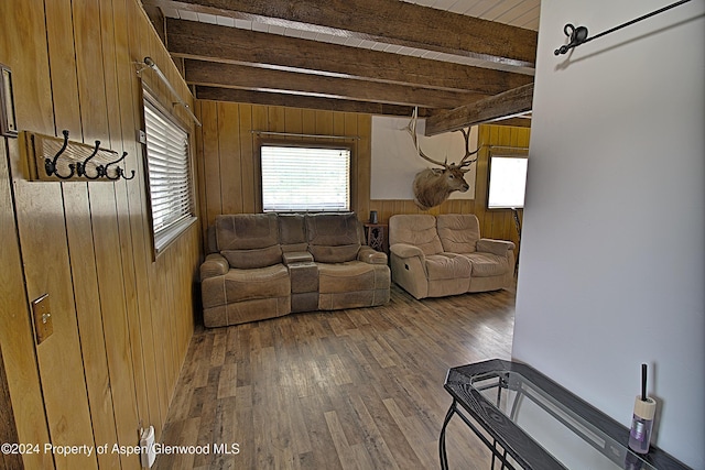 living room with wood walls, beamed ceiling, and hardwood / wood-style flooring