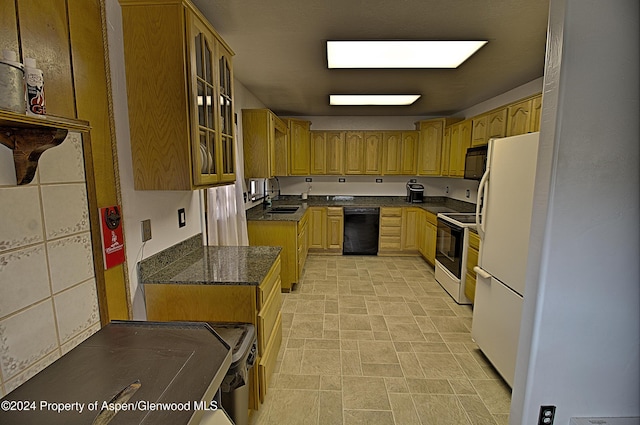 kitchen with dark stone countertops, sink, and black appliances