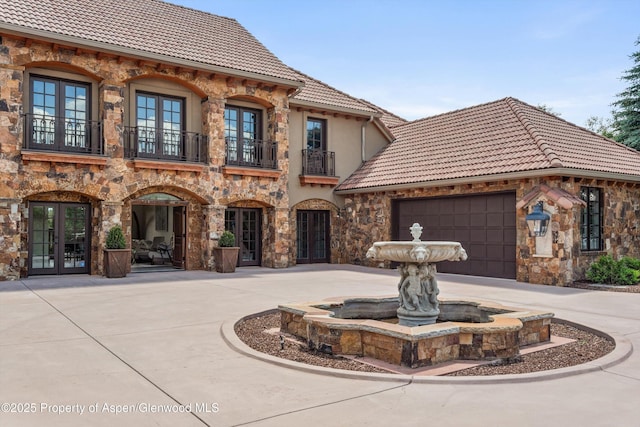 2959 County Road 103, Carbondale, CO 81623 - mediterranean / spanish house with french doors, a tile roof, a balcony, stone siding, and curved driveway