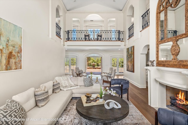 2959 County Road 103, Carbondale, CO 81623 - living room with a warm lit fireplace, wood finished floors, arched walkways, high vaulted ceiling, and french doors