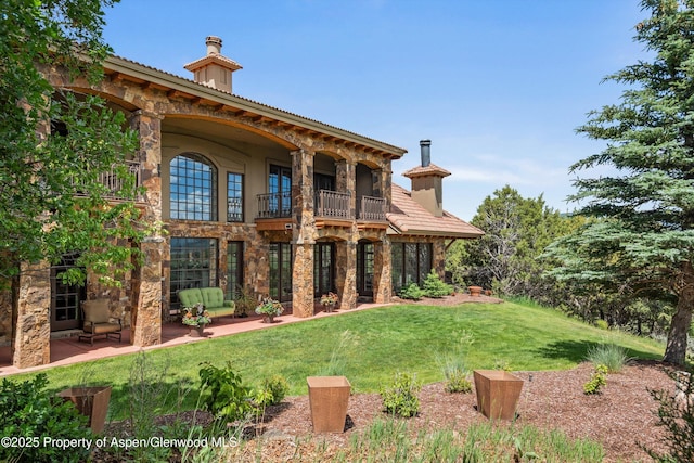 2959 County Road 103, Carbondale, CO 81623 - back of property with a balcony, stone siding, a yard, and a patio area