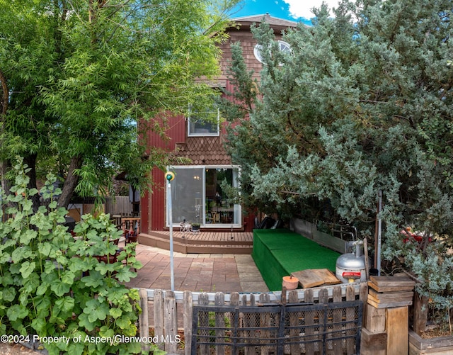 rear view of property featuring a patio area and a deck