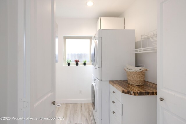 742 W Main St, New Castle, CO 81647 - laundry area with stacked washer and clothes dryer, cabinet space, baseboards, light wood-style flooring, and recessed lighting