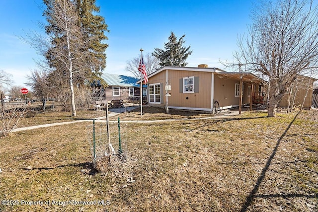 back of house featuring an attached carport and fence