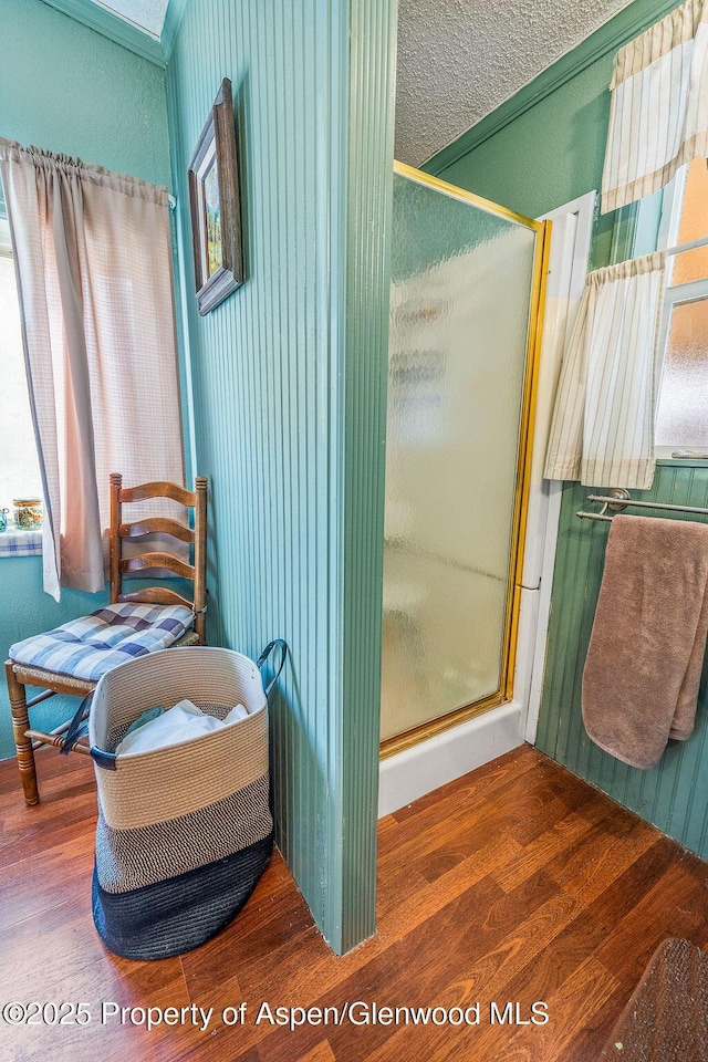 bathroom with wood finished floors and a stall shower