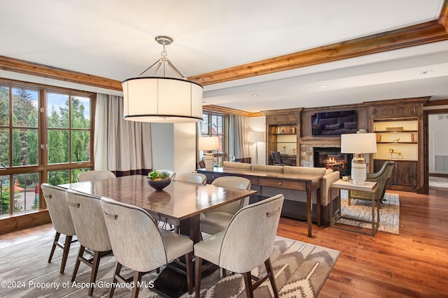 dining space with plenty of natural light, wood-type flooring, and ornamental molding