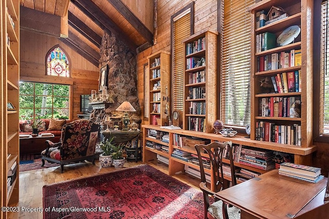 home office with beam ceiling, high vaulted ceiling, wood walls, wood-type flooring, and wood ceiling