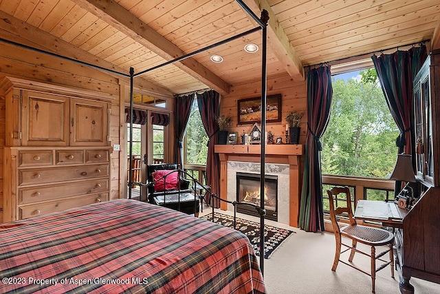 carpeted bedroom featuring lofted ceiling with beams, a fireplace, and wooden ceiling