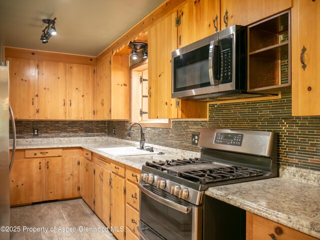 783 Orchard Rd, Montrose, CO 81401 - kitchen with appliances with stainless steel finishes, a sink, tasteful backsplash, and light stone countertops