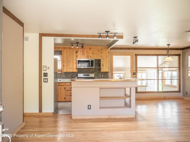 783 Orchard Rd, Montrose, CO 81401 - kitchen with stainless steel appliances, baseboards, rail lighting, light wood-type flooring, and decorative backsplash
