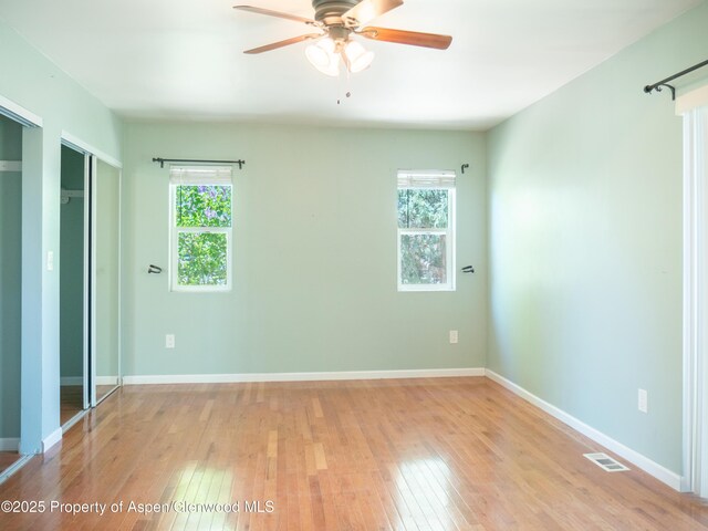783 Orchard Rd, Montrose, CO 81401 - unfurnished bedroom featuring multiple windows, hardwood / wood-style floors, baseboards, and ceiling fan