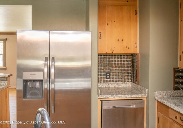 783 Orchard Rd, Montrose, CO 81401 - kitchen with stainless steel appliances, decorative backsplash, and light stone counters