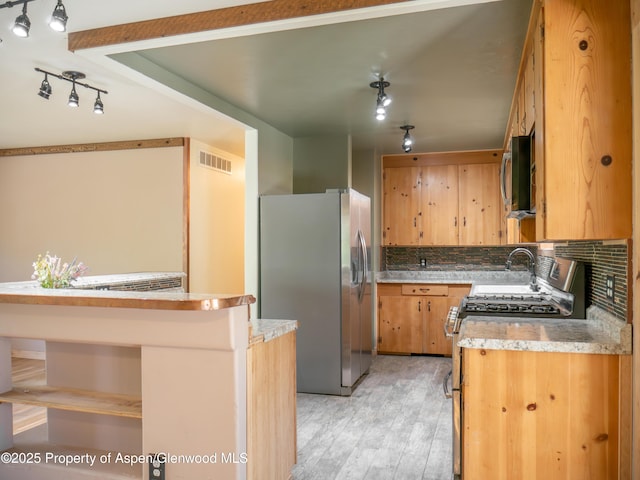 783 Orchard Rd, Montrose, CO 81401 - kitchen with appliances with stainless steel finishes, decorative backsplash, light wood-style flooring, and light countertops