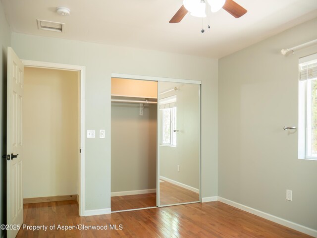 783 Orchard Rd, Montrose, CO 81401 - unfurnished bedroom featuring a closet, wood finished floors, multiple windows, and baseboards