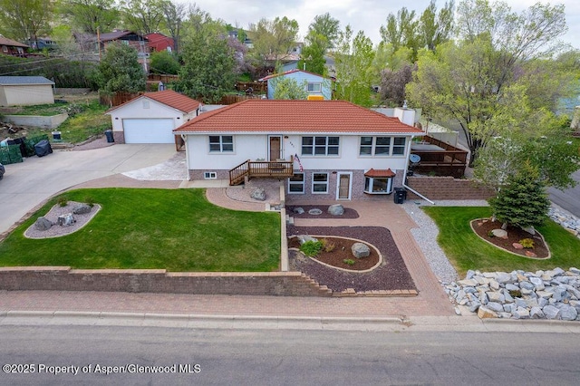 301 W 10th St, Craig, CO 81625 - mediterranean / spanish house with concrete driveway, a front lawn, a tiled roof, and an outdoor structure