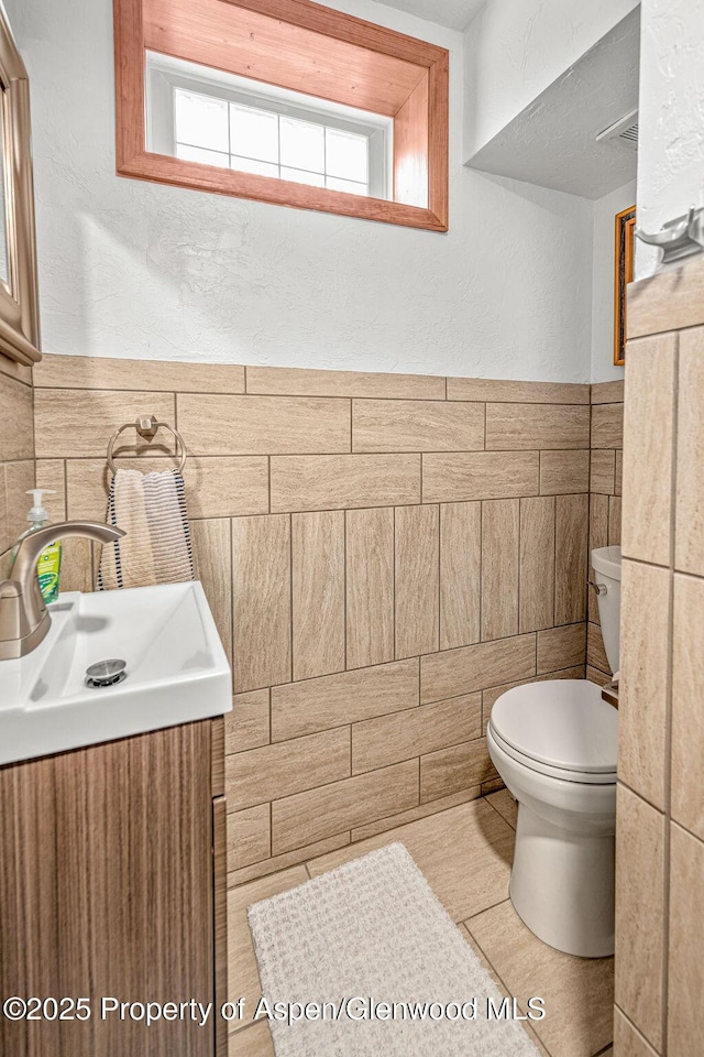 301 W 10th St, Craig, CO 81625 - bathroom with tile walls, toilet, and vanity