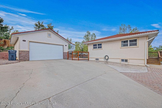 301 W 10th St, Craig, CO 81625 - view of side of home featuring stucco siding, an outbuilding, fence, and a garage