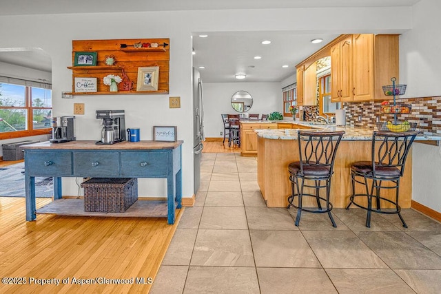 301 W 10th St, Craig, CO 81625 - kitchen with a peninsula, backsplash, recessed lighting, stainless steel fridge, and a sink