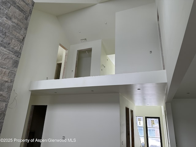 hallway featuring a towering ceiling and visible vents