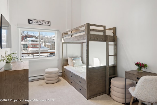 bedroom with light colored carpet and a baseboard radiator