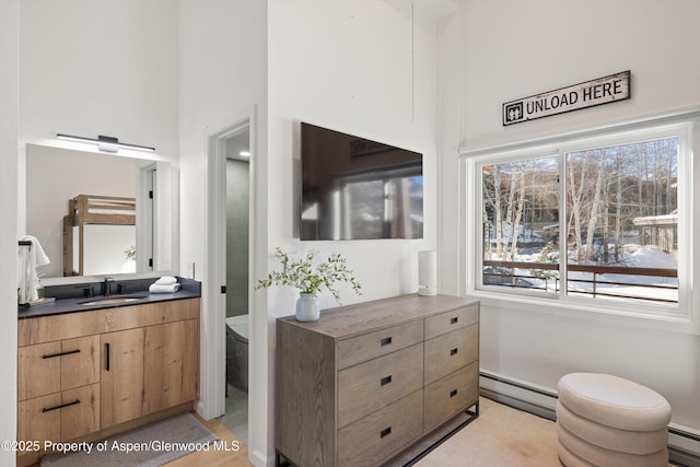 bathroom featuring vanity, toilet, and baseboard heating