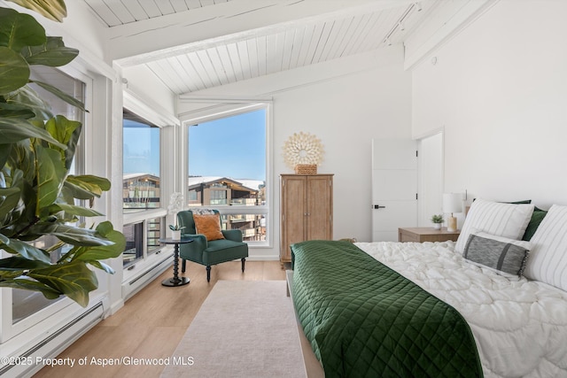 bedroom featuring lofted ceiling with beams, wooden ceiling, light wood-type flooring, and a baseboard heating unit