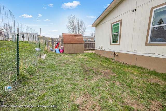 view of yard featuring fence, a shed, and an outbuilding