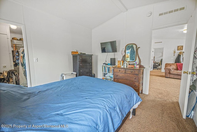 carpeted bedroom with a walk in closet, visible vents, and lofted ceiling