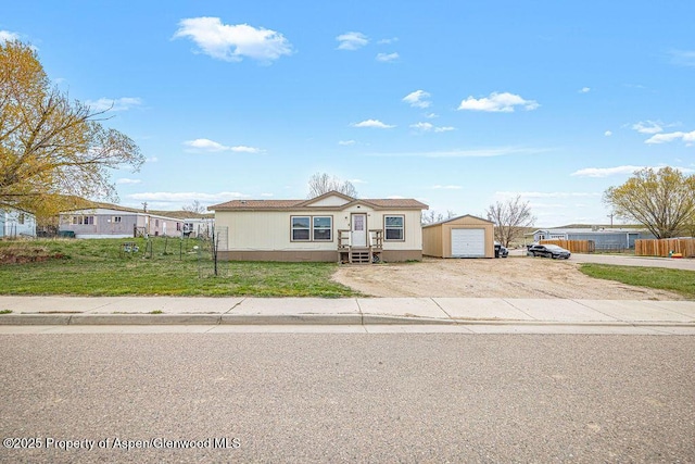 ranch-style home featuring a garage, fence, dirt driveway, and a front yard