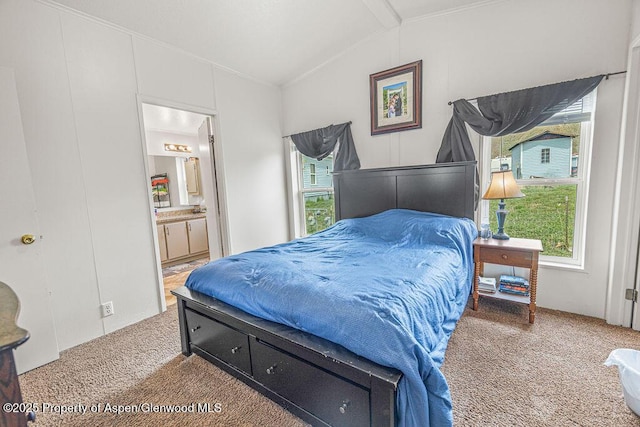 bedroom featuring ornamental molding, ensuite bath, carpet floors, and vaulted ceiling