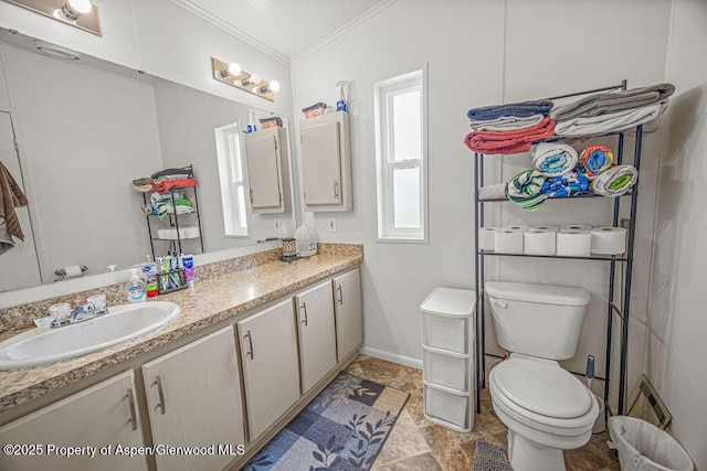 bathroom featuring ornamental molding, toilet, vanity, and baseboards