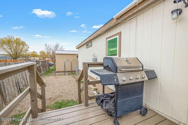 wooden terrace featuring area for grilling and fence