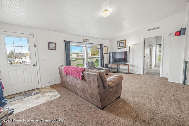 living area featuring visible vents, a textured ceiling, and carpet