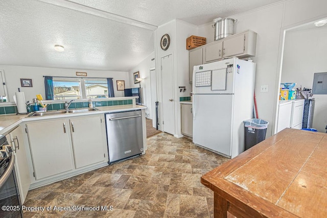 kitchen featuring a textured ceiling, stainless steel dishwasher, freestanding refrigerator, and a sink