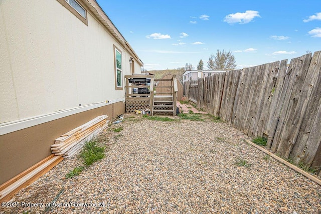 view of yard with a wooden deck and a fenced backyard