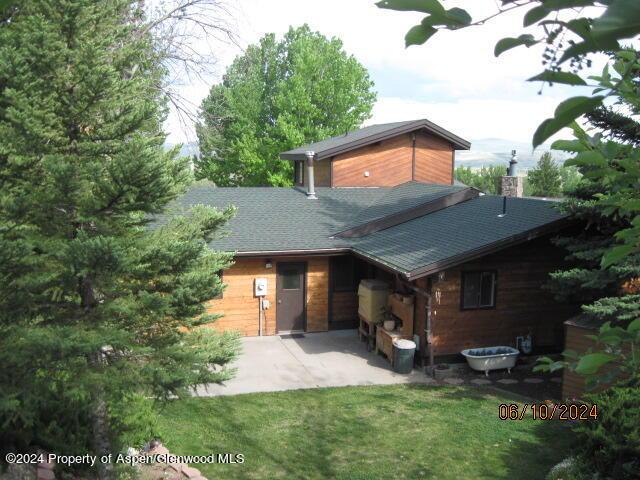 view of front of house featuring concrete driveway, a patio area, and a front lawn