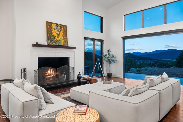 1108 County Road 110, Glenwood Springs, CO 81601 - living room with wood finished floors, a fireplace, a mountain view, a towering ceiling, and baseboards