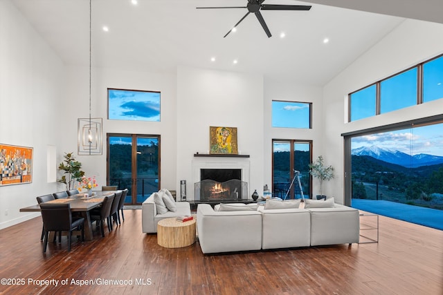 1108 County Road 110, Glenwood Springs, CO 81601 - living room with high vaulted ceiling, ceiling fan, dark wood-type flooring, recessed lighting, and a warm lit fireplace