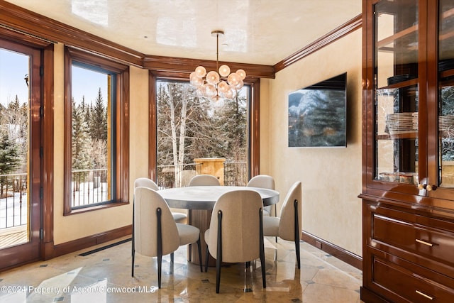 dining room featuring ornamental molding, a chandelier, and baseboards