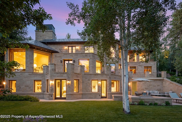 64 Pitkin Way, Aspen, CO 81611 - back of house with a balcony, outdoor lounge area, stone siding, a yard, and a patio