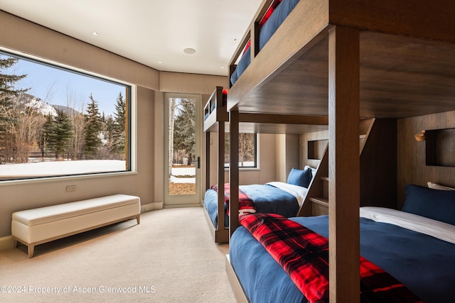 carpeted bedroom featuring multiple windows and access to exterior