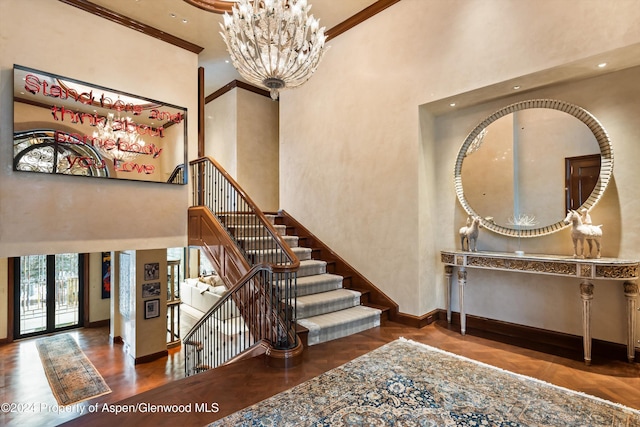 entrance foyer with a high ceiling, baseboards, a notable chandelier, and french doors