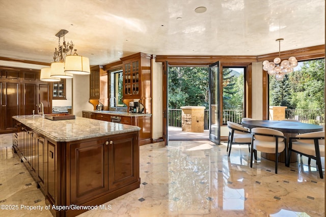 64 Pitkin Way, Aspen, CO 81611 - kitchen with light stone counters, glass insert cabinets, a chandelier, light marble finish flooring, and pendant lighting